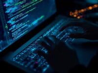 Developer working on a laptop with colorful code on screen, illustrating concepts related to how to train an LLM on your own data.